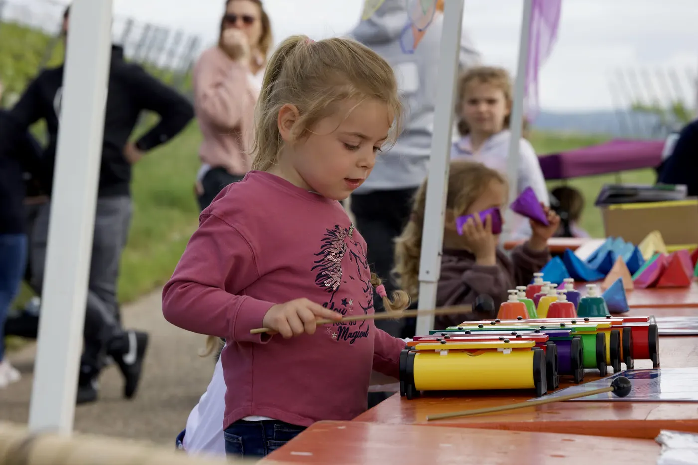Ein Mädchen spielt an einer Mitmach-Station Glockenspiel