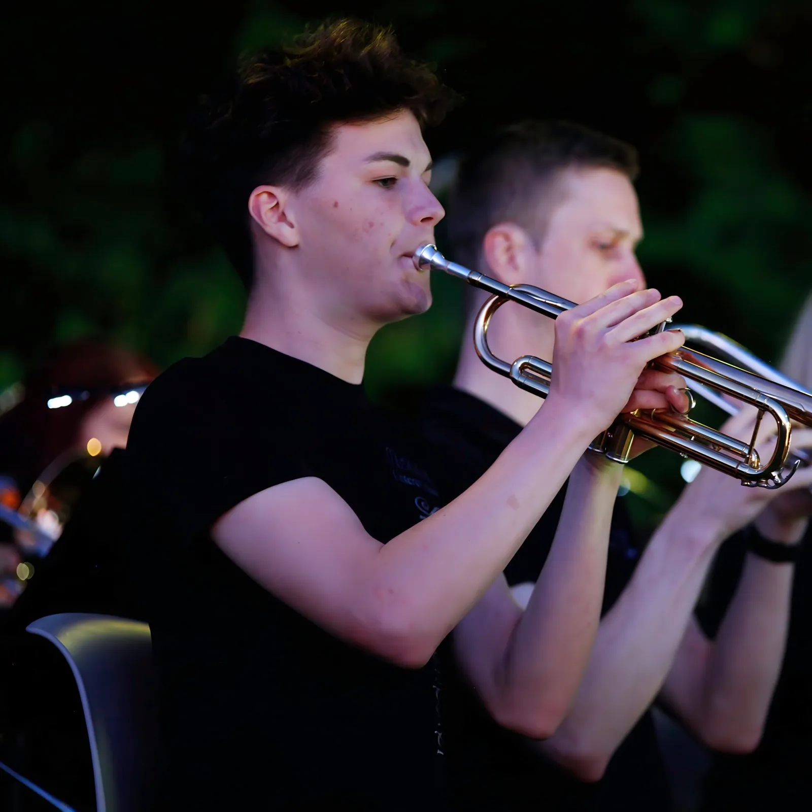 Ein Schüler spielt Trompete bei einem Abendkonzert im Freien