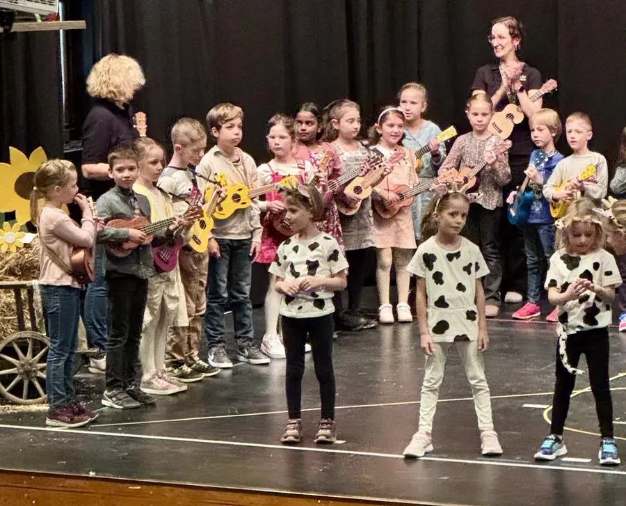 Kinder mit Ukulelen auf der Bühne bei einem Musical