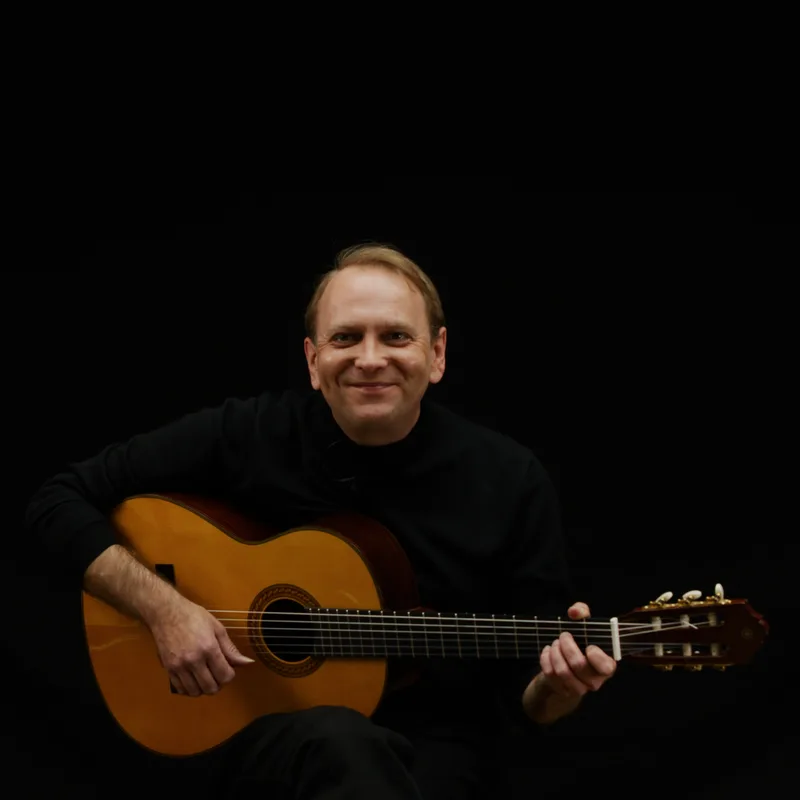 Jakub Dorofiej lacht und spielt Gitarre
