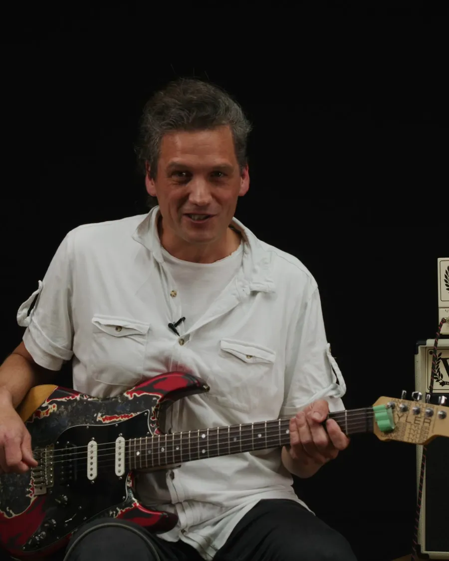 Lehrkraft der Musikschule mit E-Gitarre